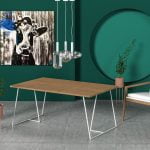 Drewniany stół z nowoczesnymi białymi nogami w zielonym nowoczesnym salonie